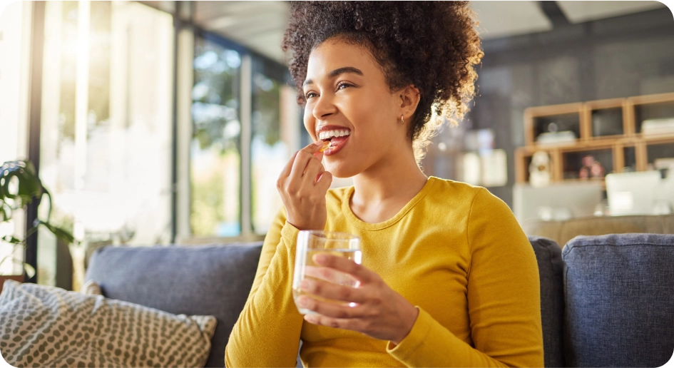 Jeune femme prenant un médicament  avec le sourire