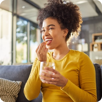 Jeune femme prenant un médicament  avec le sourire